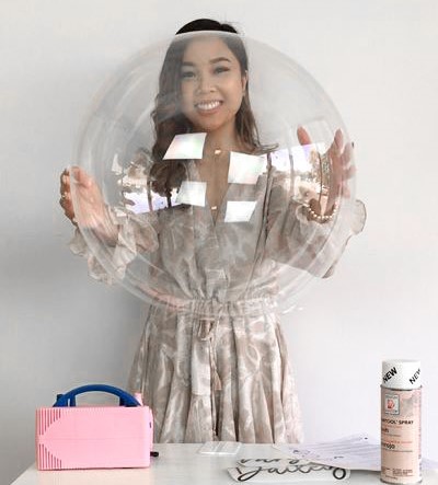 Girl holding blown up clear balloon 