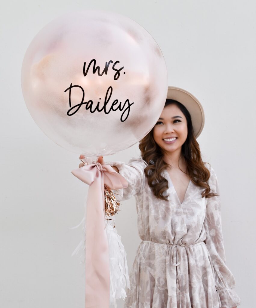 Girl holding finished DIY spray paint engagement balloon